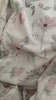 Neugeborenes Baby liegt in einem Mosesörbchen. Zugedeckt wird es von einer Babydecke in zarten Aquarelltönen (helles rosa grün). Das Motiv der Decke sind Magnolien und weitere zarte Blumen.Die Rückseite ist aus einem weichen Fleece in creme.